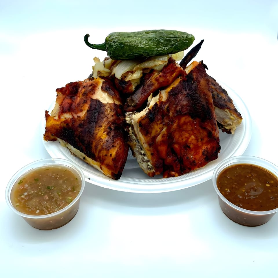 Señor Pollo's grilled chicken with charred onions, a jalapeño, and two containers of salsa.